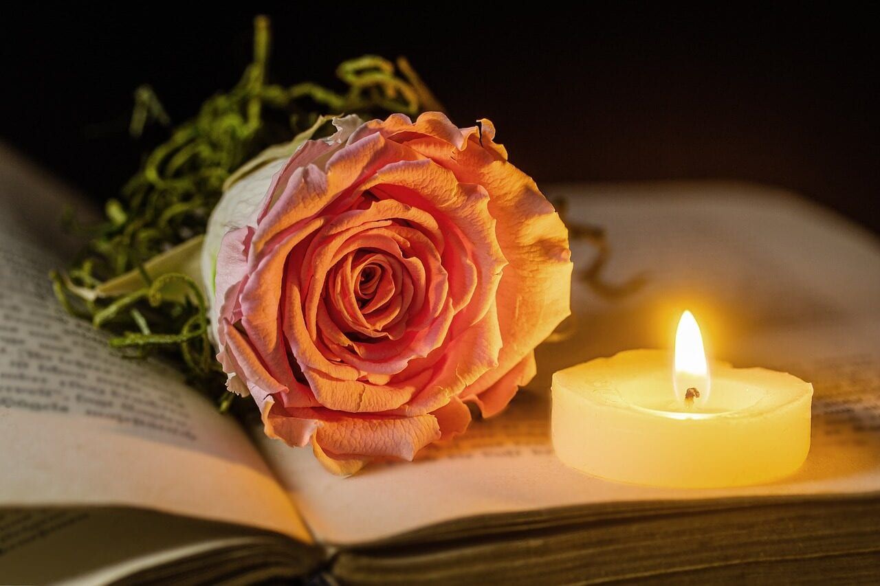 Rose und Kerze auf einem Buch
